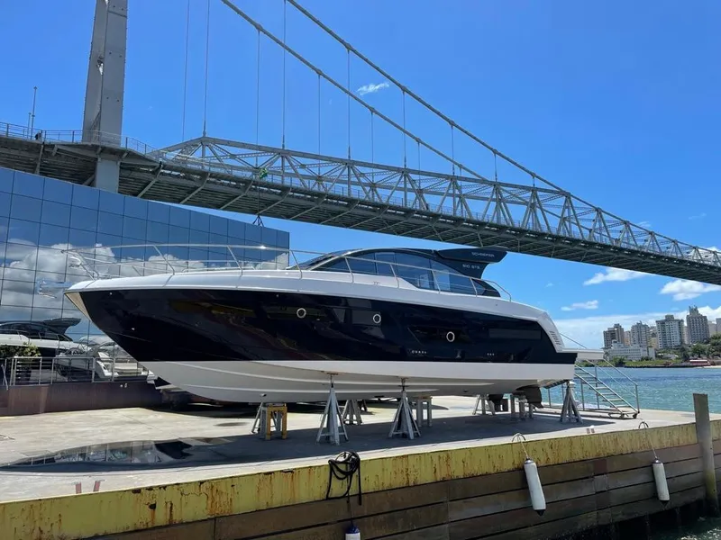 Slide: The Image of Schaefer 510 Sport 2025 yacht docked near a modern building and bridge. - 41