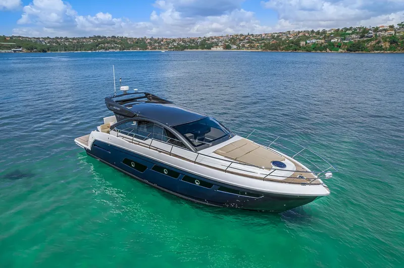 Slide: The Image of 2025 Schaefer 510 Sport yacht on clear turquoise water with coastal background. - 8