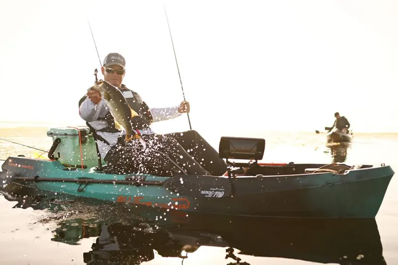 Slide: The Image of Man fishing on 2023 Old Town 106 Sportsman Minn Kota Power kayak. - 0