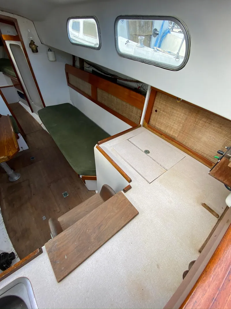 Slide: The Image of 1968 Pearson Wanderer sailboat interior with wooden accents and green seating. - 11