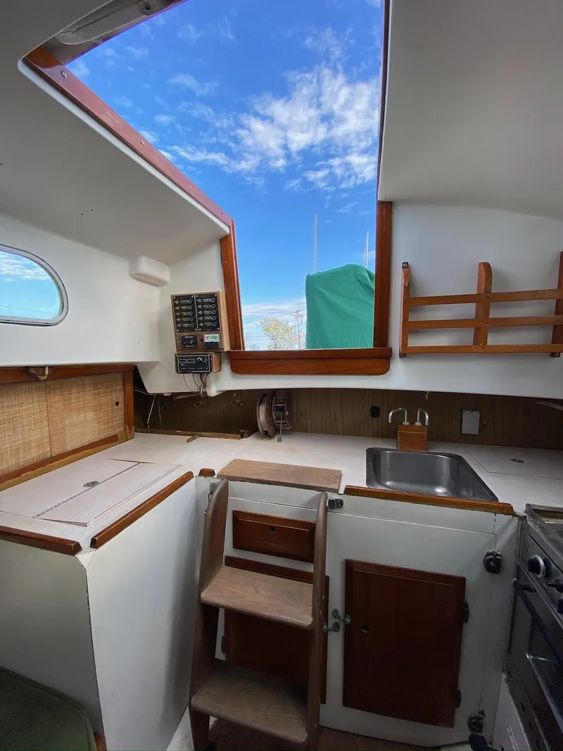 Slide: The Image of Interior of 1968 Pearson Wanderer sailboat with skylight, kitchenette, and wooden accents. - 13