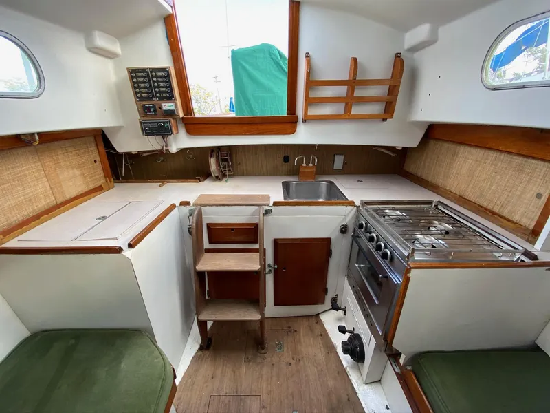 Slide: The Image of 1968 Pearson Wanderer sailboat interior with kitchen, stove, sink, and seating area. - 15