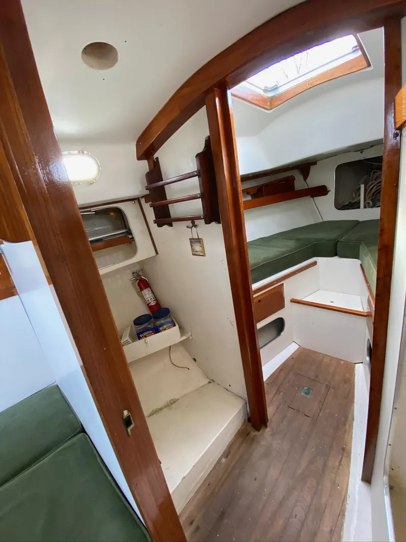 Slide: The Image of 1968 Pearson Wanderer sailboat interior with wooden accents and green seating. - 23