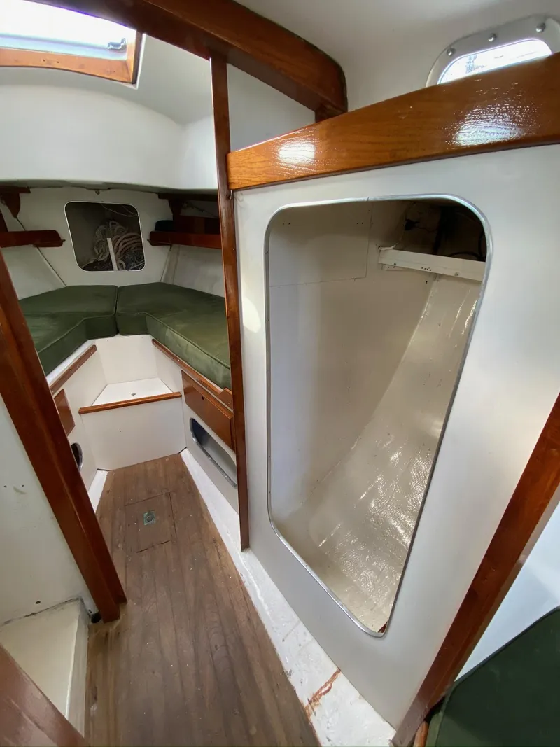 Slide: The Image of 1968 Pearson Wanderer sailboat interior with wooden accents and green cushions. - 24