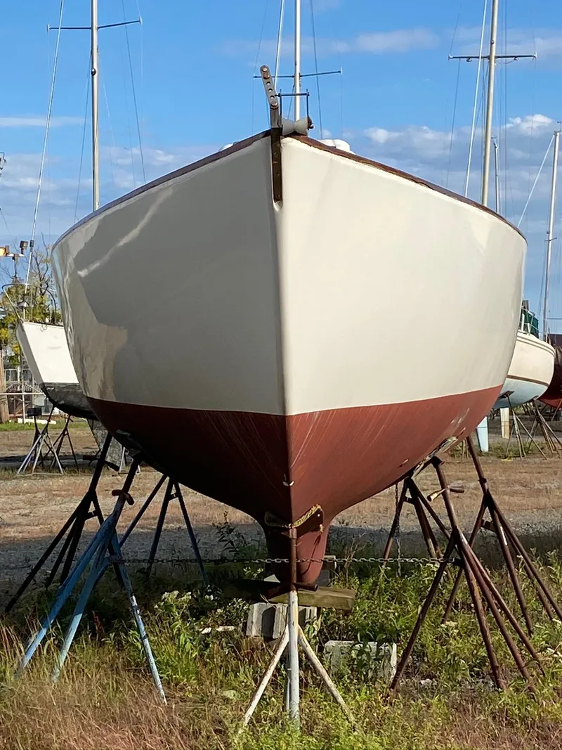 Slide: The Image of 1968 Pearson Wanderer sailboat on stands, viewed from the front, with a clear blue sky. - 6