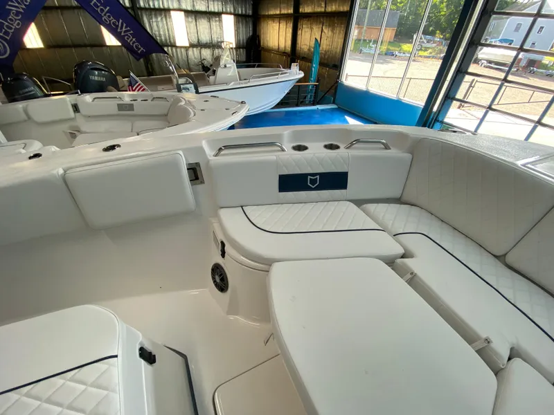 Slide: The Image of 2025 Sea Fox 268 Commander boat interior with white seating in a showroom. - 21