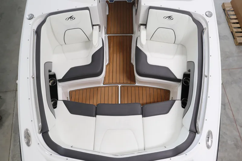 Slide: The Image of 2018 Monterey M-65 boat interior with white and gray seating, wooden flooring. - 16
