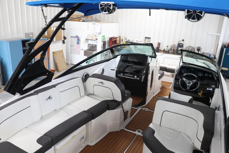 Slide: The Image of 2018 Monterey M-65 boat interior with white seating, black accents, and wooden flooring. - 5