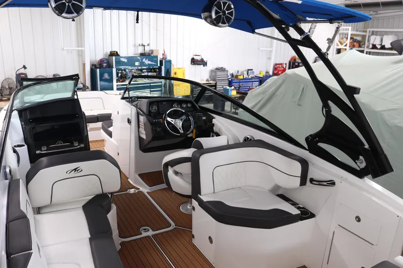 Slide: The Image of Interior of a 2018 Monterey M-65 boat with white seating and wood flooring. - 6