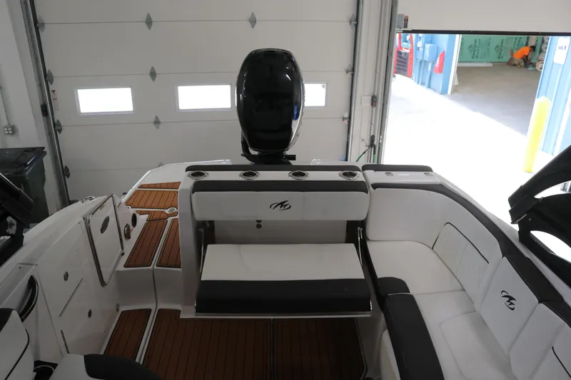 Slide: The Image of 2018 Monterey M-65 boat interior with seating and wood flooring in a garage setting. - 7