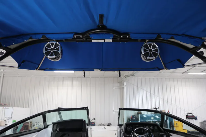 Slide: The Image of 2018 Monterey M-65 boat interior with blue canopy and mounted speakers. - 8