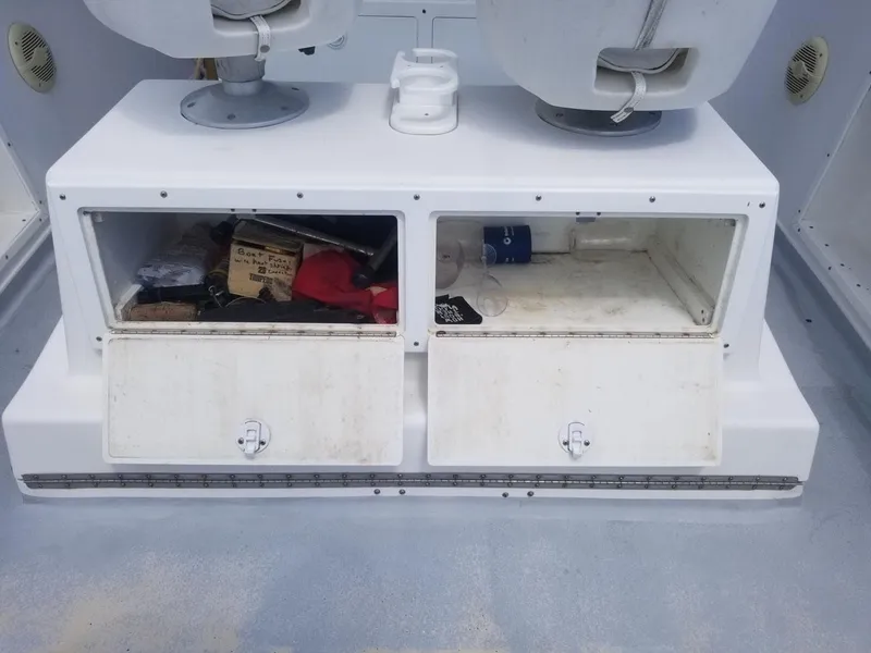 Slide: The Image of 1977 Pace Wahoo boat storage compartments with open doors, showing various items inside. - 11
