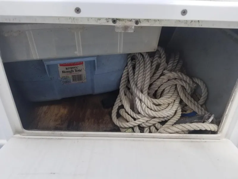 Slide: The Image of Storage compartment with coiled rope and blue container on a 1977 Pace Wahoo boat. - 6