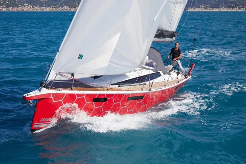 The Image of 2025 Dehler 38 SQ sailboat with red hull sailing on blue ocean. - 0