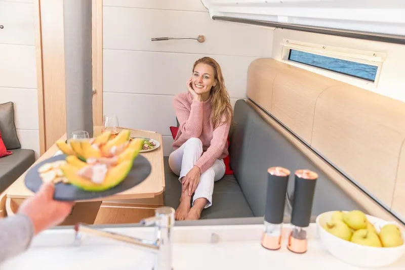 Slide: The Image of Interior of 2025 Dehler 38 SQ yacht with a woman dining. - 23