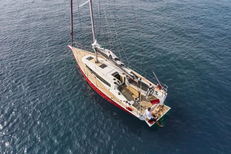 Slide: The Image of 2025 Dehler 38 SQ sailing yacht with red hexagonal pattern on the water. - 4