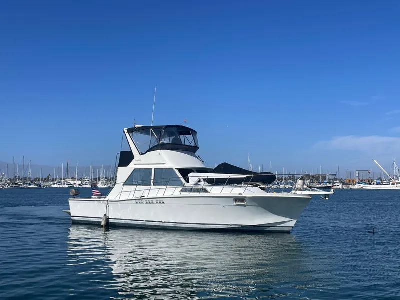 The Image of 1973 Uniflite 42 Flybridge yacht on calm water, with marina in the background. - 0