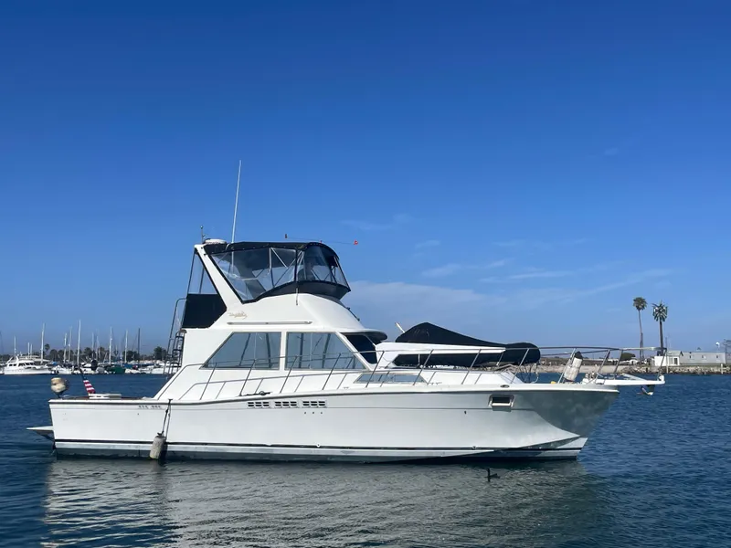 Slide: The Image of 1973 Uniflite 42 Flybridge yacht on calm water under clear blue sky. - 1