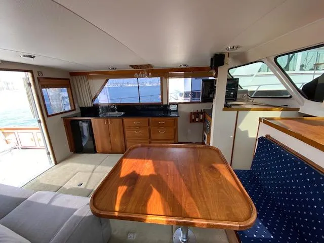 Slide: The Image of Interior of 1973 Uniflite 42 Flybridge with wooden table and kitchenette. - 13