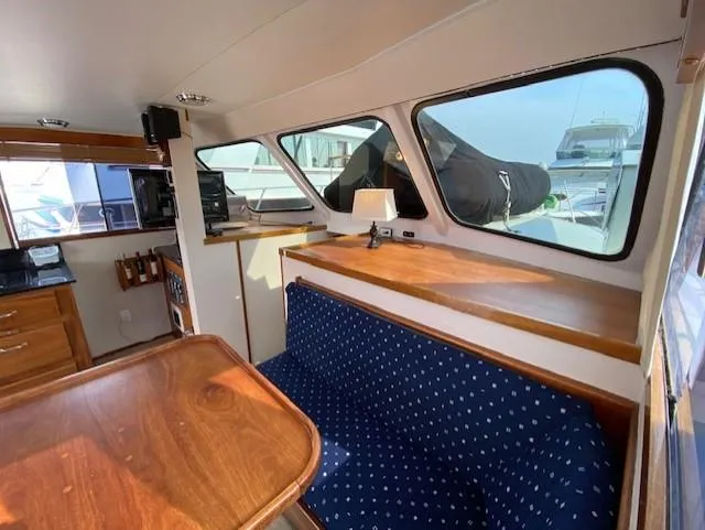 Slide: The Image of Interior of 1973 Uniflite 42 Flybridge with wooden table and blue cushioned seating. - 14