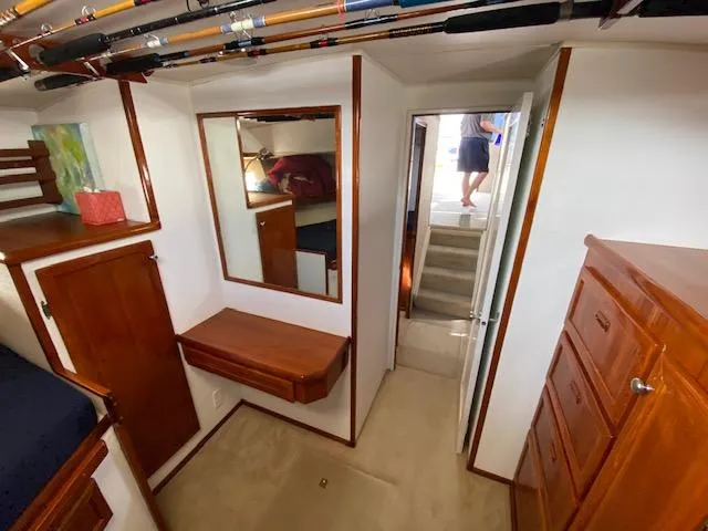 Slide: The Image of 1973 Uniflite 42 Flybridge interior with wood cabinetry, mirror, and fishing rods overhead. - 17