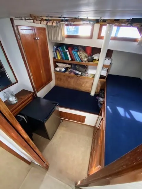 Slide: The Image of 1973 Uniflite 42 Flybridge cabin interior with seating, storage, and mini fridge. - 23