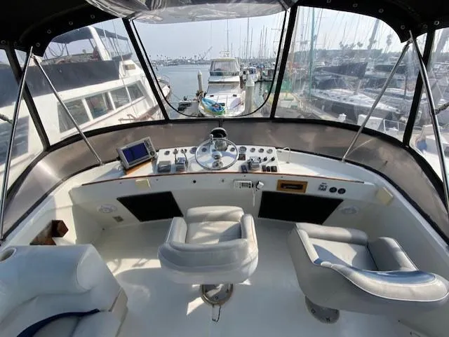 Slide: The Image of 1973 Uniflite 42 Flybridge helm with dual seats and marina view. - 26