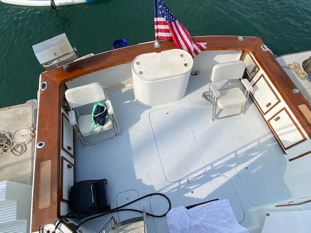 Slide: The Image of 1973 Uniflite 42 Flybridge boat deck with chairs and American flag. - 28