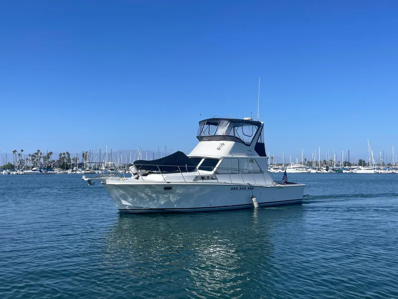 Slide: The Image of 1973 Uniflite 42 Flybridge yacht on calm water with marina background. - 3