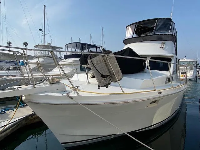 Slide: The Image of 1973 Uniflite 42 Flybridge yacht docked in marina, featuring spacious deck and flybridge. - 4