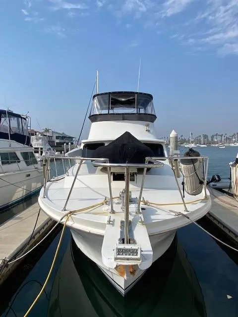 Slide: The Image of 1973 Uniflite 42 Flybridge yacht docked at marina under clear sky. - 6