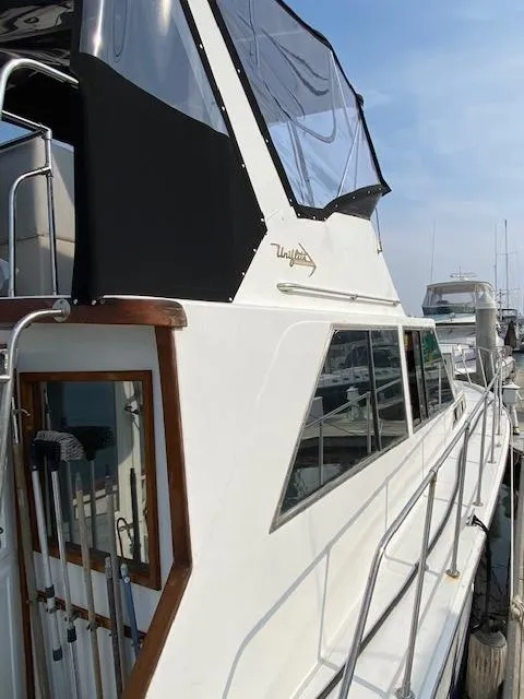 Slide: The Image of 1973 Uniflite 42 Flybridge yacht docked at marina, featuring sleek design and spacious flybridge. - 8