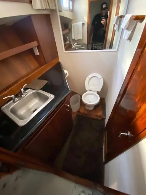 Slide: The Image of 1973 Uniflite 42 Flybridge bathroom with sink, toilet, and mirror. - 19