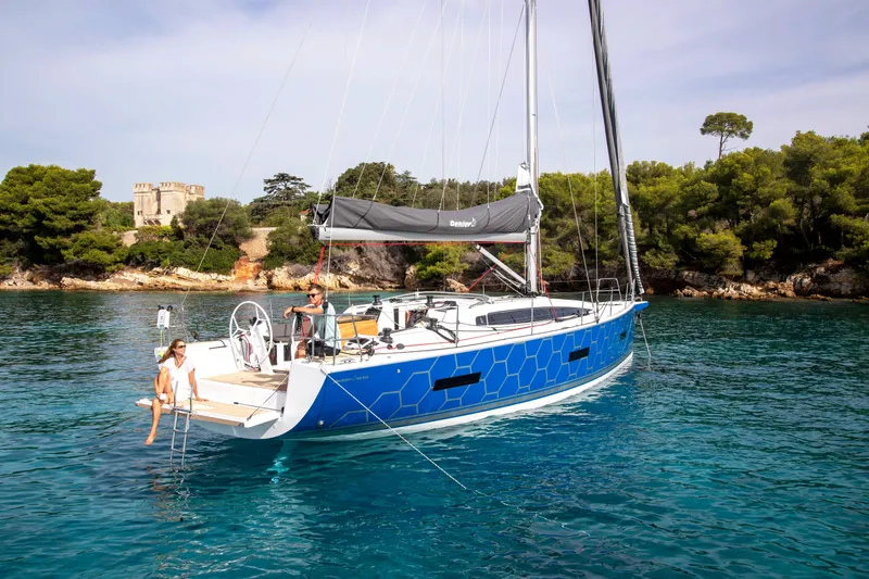 Slide: The Image of 2026 Dehler 46SQ sailboat cruising on blue ocean with scenic coastal backdrop. - 59