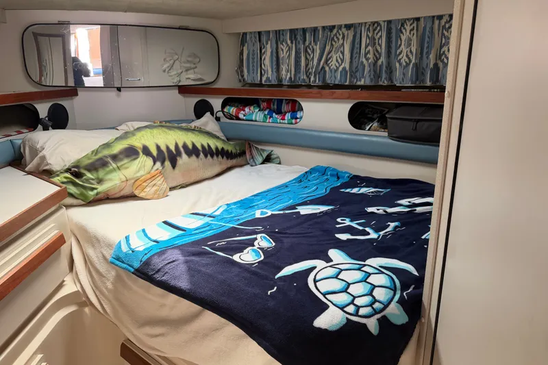 Slide: The Image of Cozy cabin interior of 1988 Carver 32 Montego with nautical-themed bedding and fish pillow. - 14