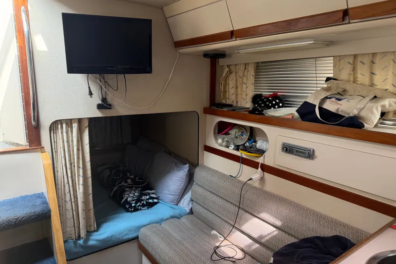 Slide: The Image of Interior of a 1988 Carver 32 Montego boat with TV, seating, and storage. - 15