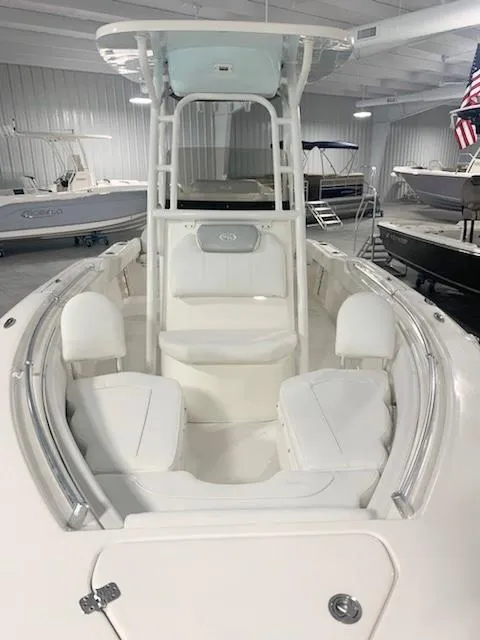 Slide: The Image of 2024 Key West 219 FS boat interior with white seating and T-top in showroom. - 8