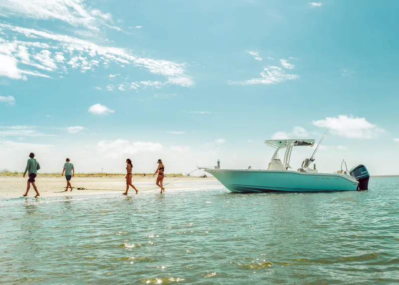 Slide: The Image of 2024 Key West 219 FS boat anchored on a sunny beach with people walking. - 9