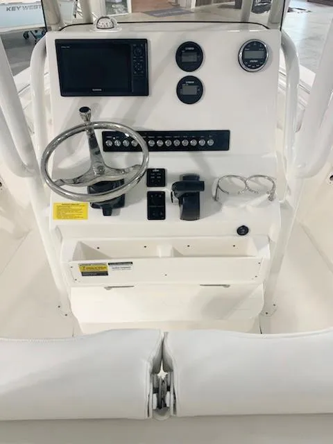 Slide: The Image of 2024 Key West 219 FS boat console with steering wheel, gauges, and controls. - 2