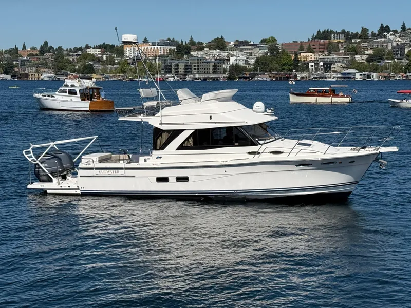 The Image of 2020 Cutwater C 32 CB boat on a calm lake with cityscape background. - 0
