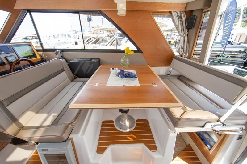 Slide: The Image of Interior of 2020 Cutwater C 32 CB boat with elegant seating and wooden table. - 11