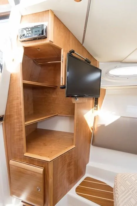 Slide: The Image of 2020 Cutwater C 32 CB interior with wooden shelves and mounted TV. - 13