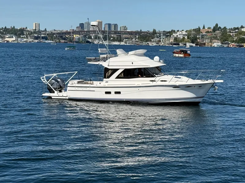 Slide: The Image of 2020 Cutwater C 32 CB yacht cruising on a scenic urban waterway. - 16