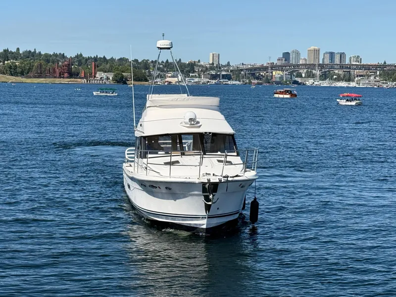 Slide: The Image of 2020 Cutwater C 32 CB boat on a scenic lake with city skyline. - 2