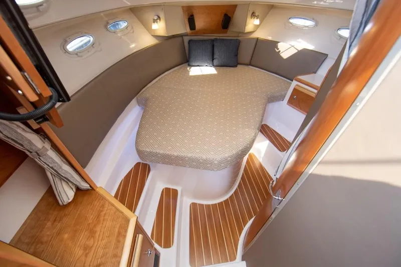 Slide: The Image of 2020 Cutwater C 32 CB cabin interior with cozy bed and wooden accents. - 6