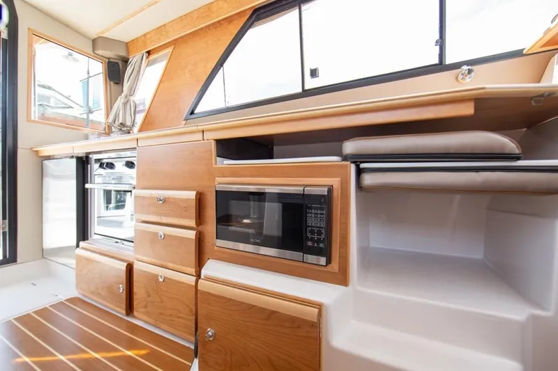 Slide: The Image of 2020 Cutwater C 32 CB interior with modern kitchen, featuring wood cabinetry and appliances. - 7