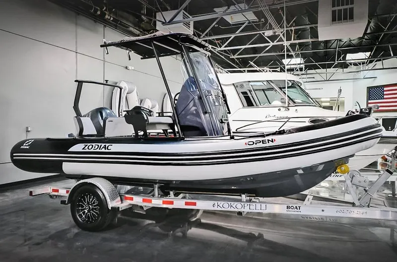 The Image of 2023 Zodiac Open 5.5 boat on a trailer in a showroom. - 0
