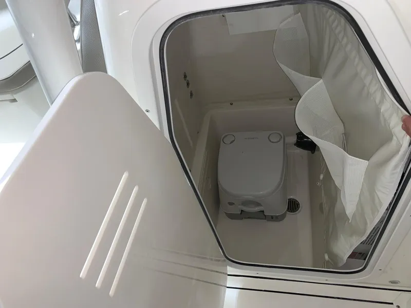 Slide: The Image of 2024 Key West 244 Center Console boat interior with a compact marine toilet. - 17