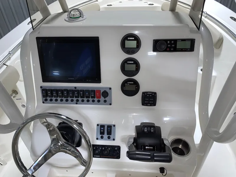 Slide: The Image of 2024 Key West 244 Center Console boat dashboard with steering wheel, gauges, and electronic controls. - 8