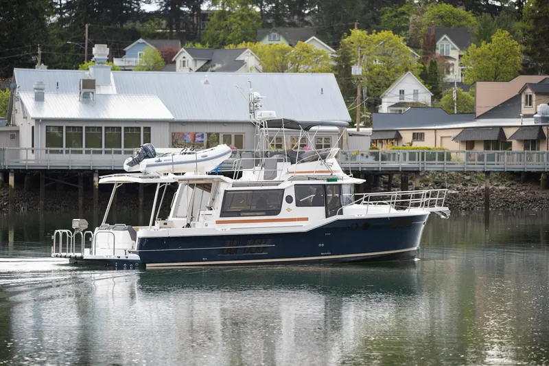 The Image of 2025 Ranger Tugs R-43 Command Bridge Luxury Edition in a serene harbor setting. - 0